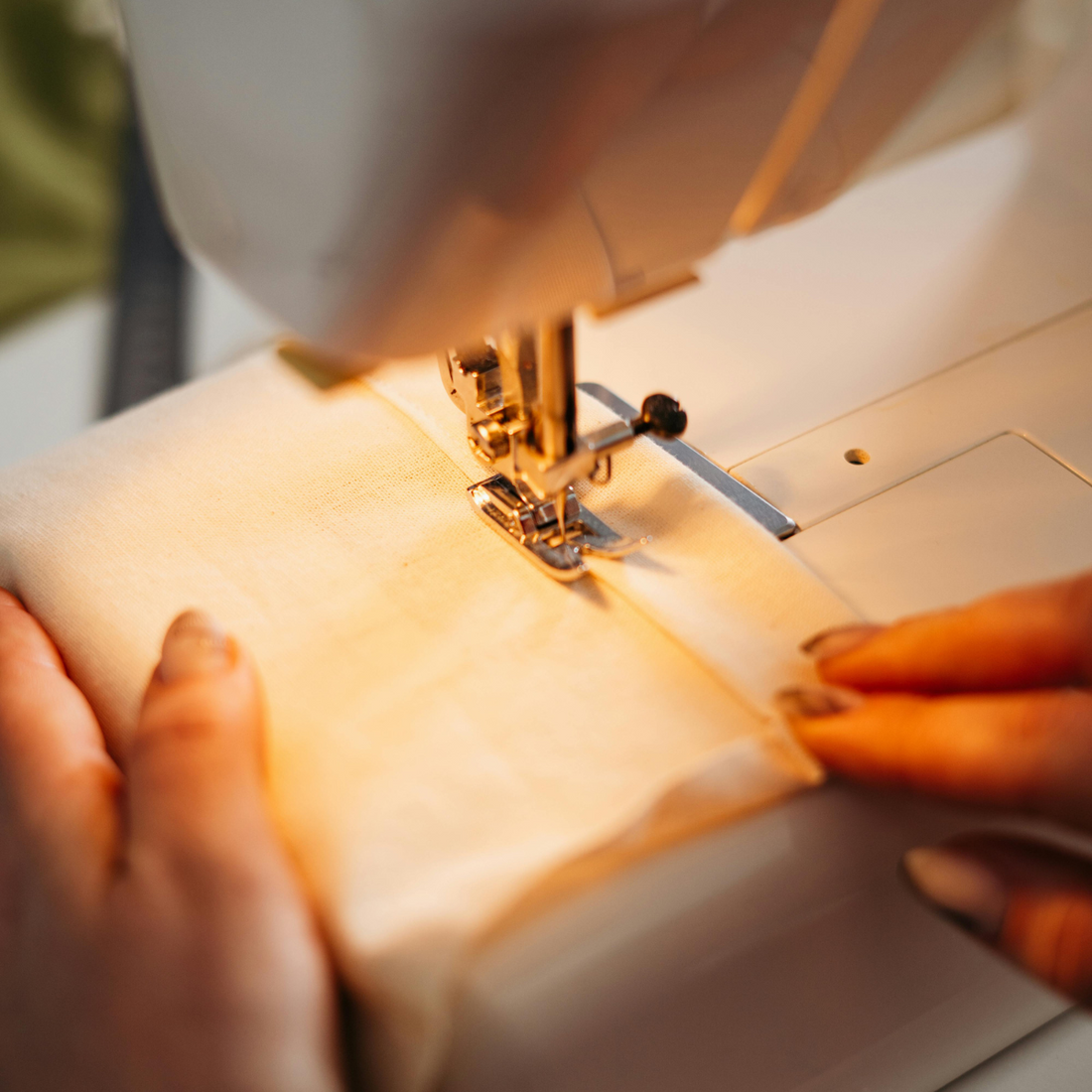 manos de una señora confeccionando un ibbibbi en una máquina de coser.
