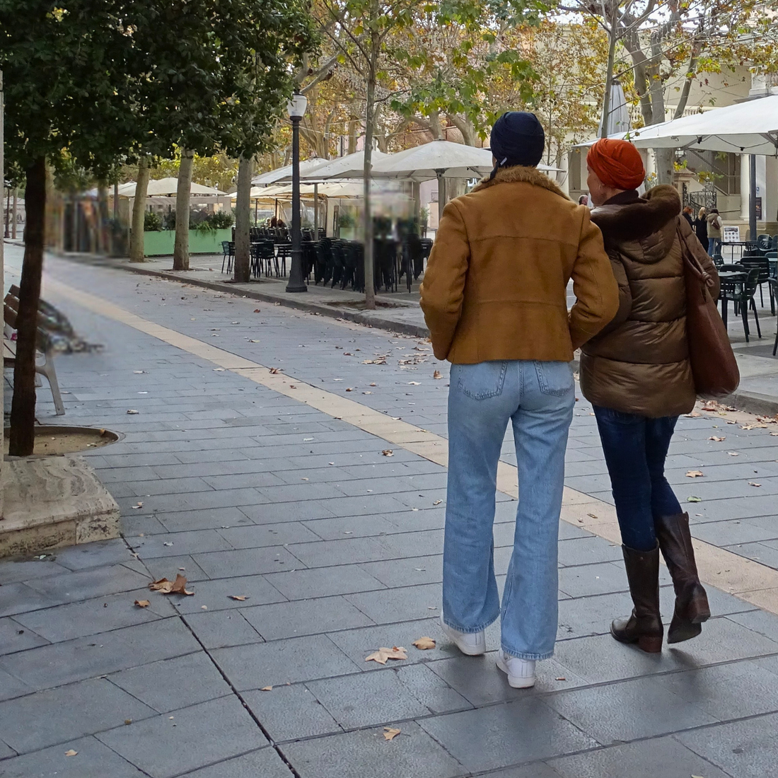 Dos mujeres caminando de espaldas al aire libre, llevando pañuelos oncológicos iBBIBBI, en una imagen luminosa que transmite acompañamiento y avance.